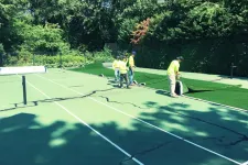 Thumbnail for a group of people stand on a tennis court