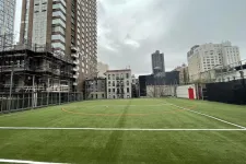 Thumbnail for a football field with buildings in the background