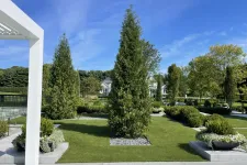 Thumbnail for a large green lawn with trees and a white building in the background
