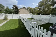 Thumbnail for a white fence with a white picket fence and a house in the background