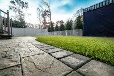 Thumbnail for a concrete walkway with grass and a fence and trees