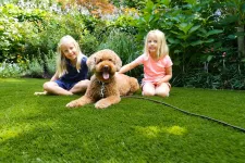 Thumbnail for two girls sitting on grass with a dog
