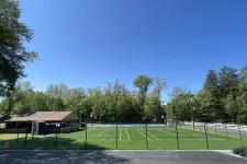 Thumbnail for a tennis court with trees in the background