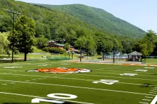 Thumbnail for a football field with a hill in the background