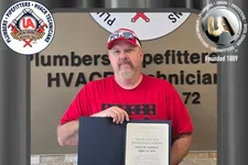 Thumbnail for Man in red shirt holding a 25-year membership certificate at Plumbers Pipefitters HVACR Technicians Local Union 72.
