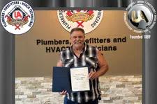 Thumbnail for Man holding certificate celebrating 55 years with Plumbers, Pipefitters, and HVACR technicians Local Union 72.