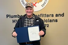 Thumbnail for a man holding a certificate