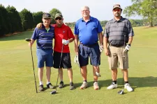 Thumbnail for a group of people posing for a photo on a golf course