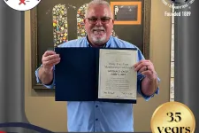 Thumbnail for a man holding a certificate