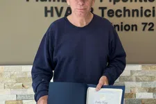 Thumbnail for Man in a cap holding a certificate stands by a wall with a Plumbers and Pipefitters Union 72 sign and overlaid text.