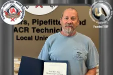 Thumbnail for Man holding a 45-year membership certificate from UA Local Union 72 in front of union signage.