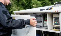 Thumbnail control image for Technician servicing machinery with control panel in a natural outdoor setting.