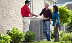 Thumbnail control image for A technician shakes hands with homeowners beside a newly installed air conditioning unit.