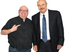 Two men posing, one pointing and smiling in casual wear, the other in a suit and tie against a white background