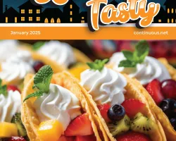 Colorful fruit tacos with whipped cream and mint leaves on a plate, featured on a January 2025 magazine cover.