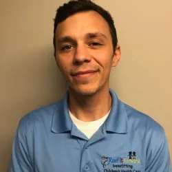 a man in a blue shirt and smiling at the camera