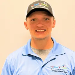 Smiling man wearing a blue shirt and cap promoting Roof It Forward benefiting Children's Health Care.