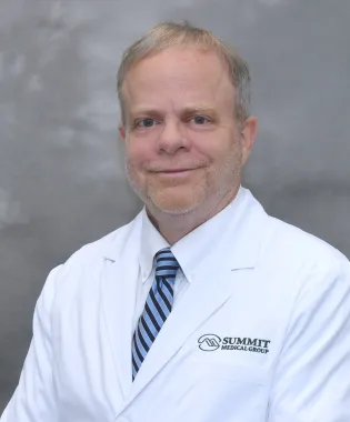 a man wearing a white coat and blue tie.