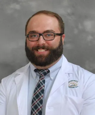 a man wearing glasses posing for the camera.
