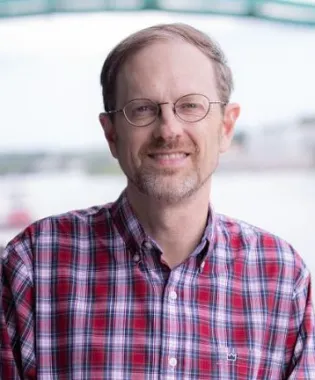 a man wearing glasses posing for the camera.