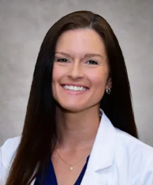 Smiling female medical professional in a lab coat posing for a portrait image..