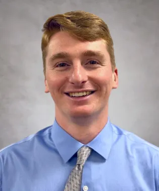 a man wearing a blue shirt and tie.