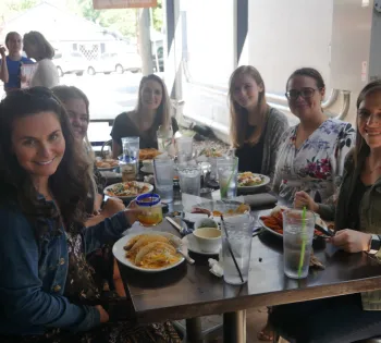 a group of people sitting at a table eating food