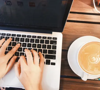 a person using a laptop computer sitting on top of a table