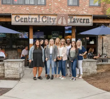 a group of women posing for a photo in front of a restaurant