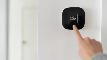 a hand holding a black square object