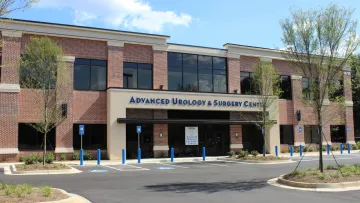 Exterior view of Advanced Urology & Surgery Center with landscaped entrance and blue parking spaces.