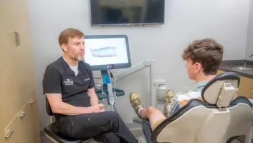 a person sitting in a chair next to a person in a wheelchair