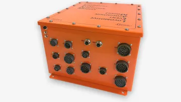Orange electronic junction module with multiple circular connectors and metal screws on a white background.