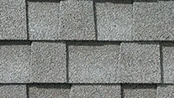 Modern house with gray asphalt shingle roof and beige exterior walls next to a close-up of gray shingle pattern