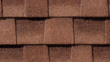 Suburban house with brown asphalt shingle roof and detailed close-up of roofing material texture