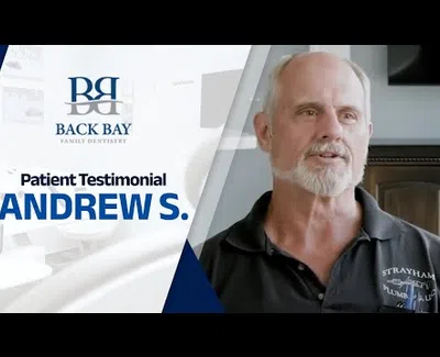 Smiling older man sharing his testimonial for Back Bay Family Dentistry with logo and name Andrew S.