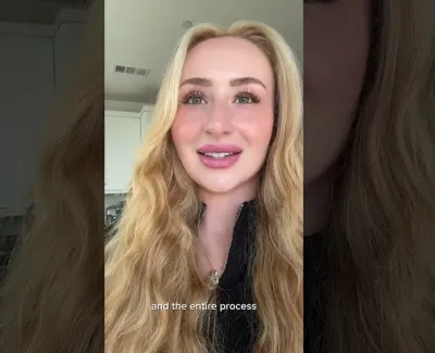 Blonde woman with long wavy hair smiling in a kitchen setting, wearing a black top, with caption text.