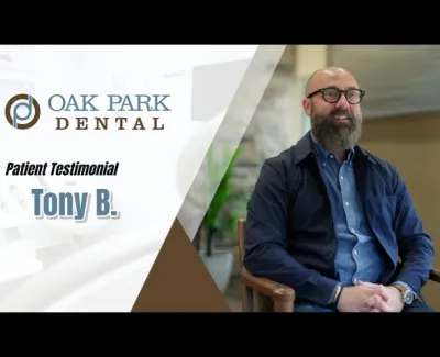A man with glasses and a beard giving a dental patient testimonial at Oak Park Dental office.