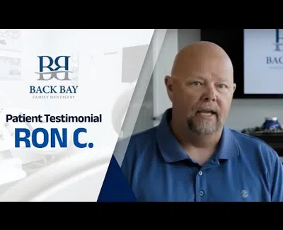 Middle-aged man sharing a patient testimonial for Back Bay Family Dentistry in a professional setting.