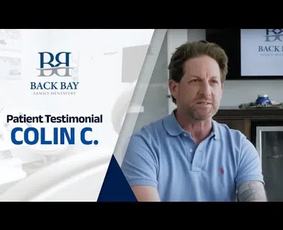 Patient testimonial from Colin C at Back Bay Family Dentistry with dental office background.