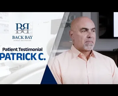 Middle-aged man giving a testimonial for Back Bay Family Dentistry in a professional setting.