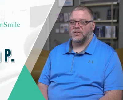 Patient Keith P. shares his testimonial for Levenson Smile dental care in a blue shirt and glasses.