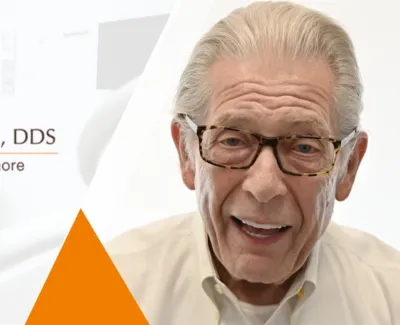 Smiling elderly man wearing glasses with Paul Lee DDS dental office logo and tagline smile more