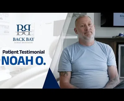 Patient testimonial from Noah O. at Back Bay Family Dentistry with a man sitting and smiling.