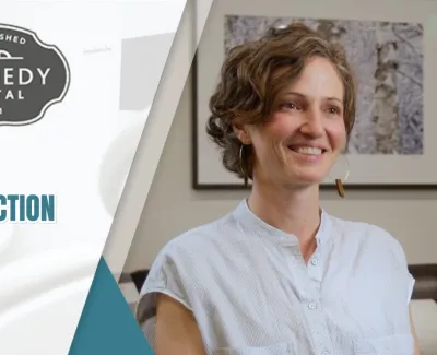 Smiling woman shares patient testimonial about Ember extraction and implant at Kennedy Dental.