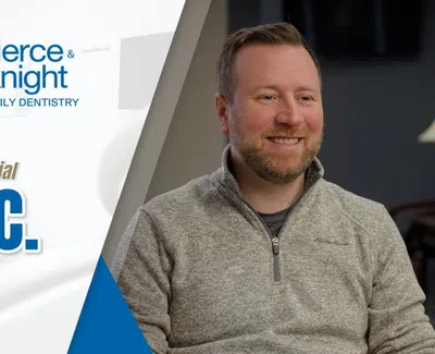 Smiling man in gray sweater shares patient testimonial for Pierce & Knight Family Dentistry.