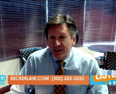 Man in office wearing dress shirt and tie speaking with contact info for Becker Law on screen