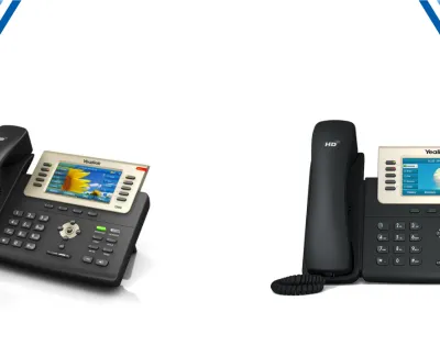 Two Yealink office IP phones with color displays and multiple function buttons for communication.