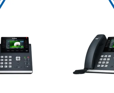 Two black Yealink office desk phones with color screens, numeric keypads, and handsets against white background.