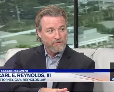 Attorney Carl E. Reynolds III speaking during a sponsored segment on a news show with outdoor view background.